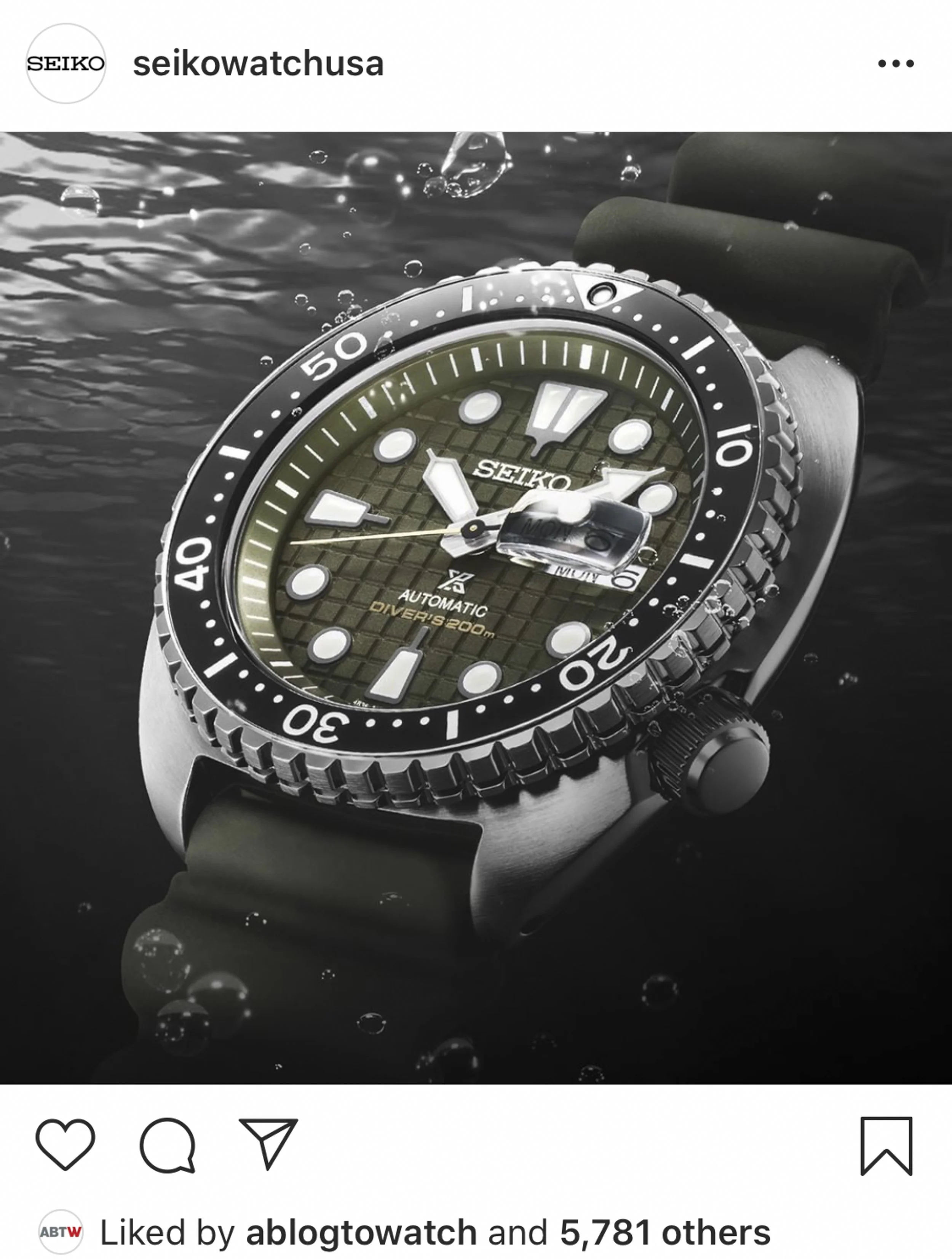 Close-up of a Seiko diver's watch underwater, showing the dial with large luminous markers, a rotating bezel, and a black strap.