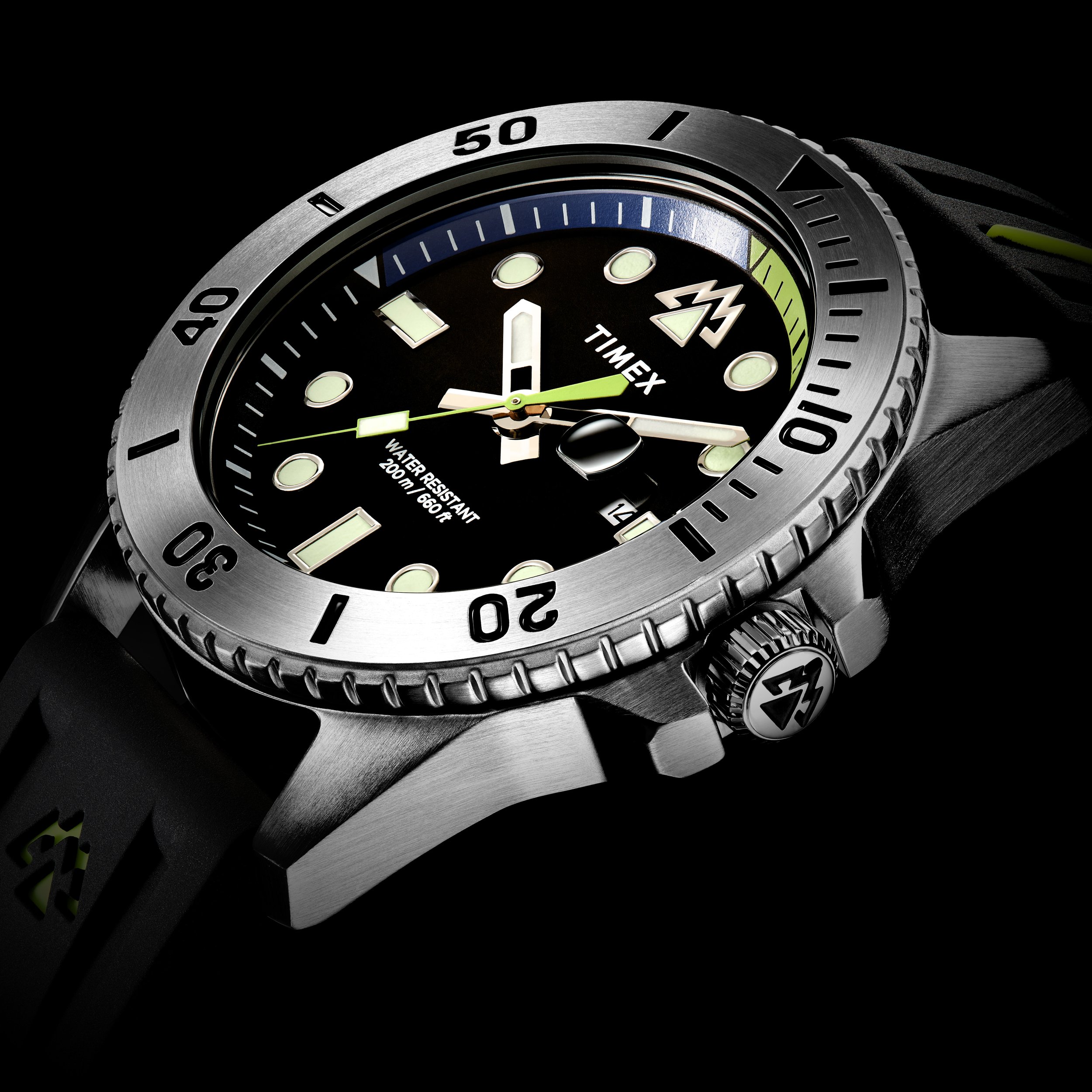 Close-up of a Timex diver's watch with a black dial, luminous hour markers and hands, a date window, a unidirectional bezel, and a black strap.