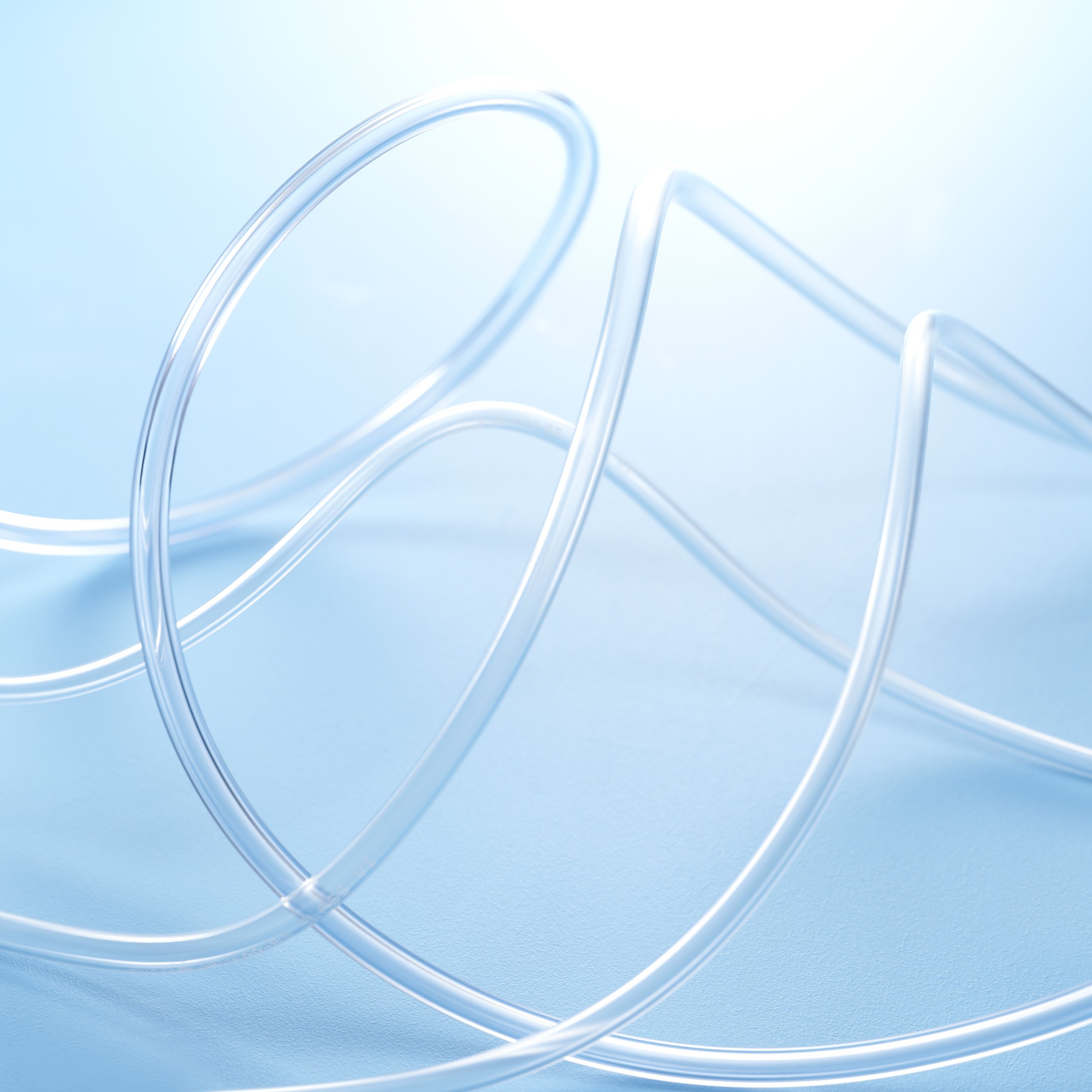 Close-up of translucent medical tubing or wire on a light blue background.