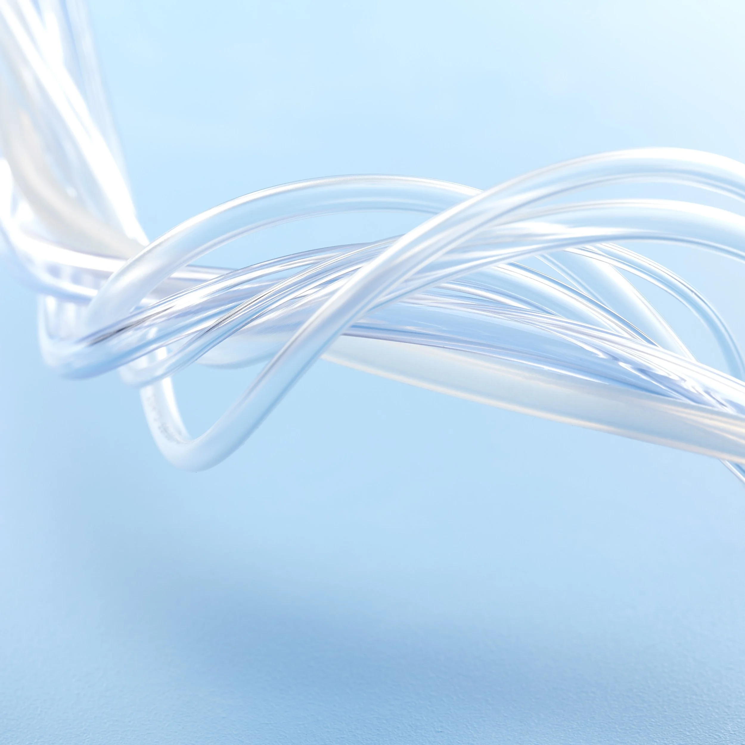 Close-up of clear, intertwined plastic or glass tubes against a light blue background.