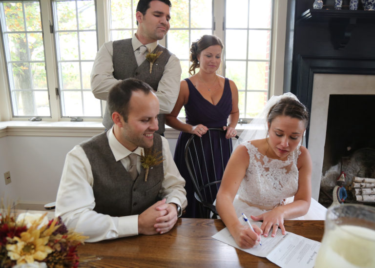 Signing the self uniting marriage license with their witnesses