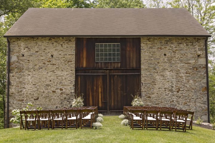 The barn on their property was a great backdrop for their wedding ceremony. Inside the barn were several vintage VW bugs and a VW bus! Photo by Captured by Missi.