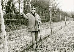 Walter stands beside his deer and rabbit proof fence.