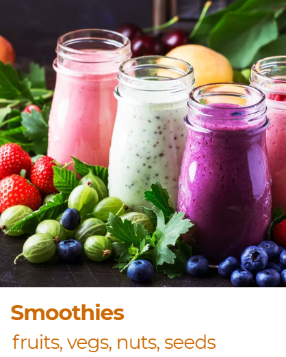Three jars of colorful smoothies surrounded by assorted fresh fruits and vegetables such as strawberries, blueberries, gooseberries, cherries, apples, and leafy greens.