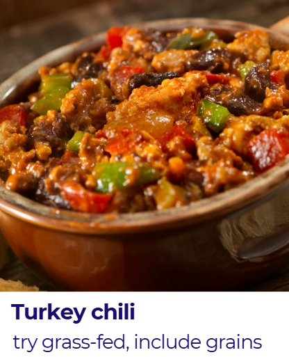A bowl of turkey chili with ground turkey, red and green bell peppers, black beans, and corn in a rich tomato sauce.