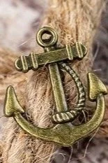 Close-up of a brass anchor attached to a wooden surface.
