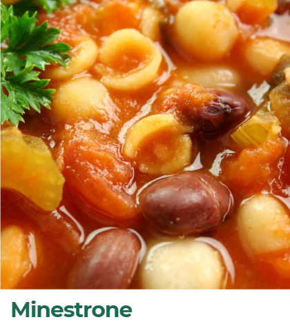 Close-up of Minestrone soup with beans, vegetables, and herbs.