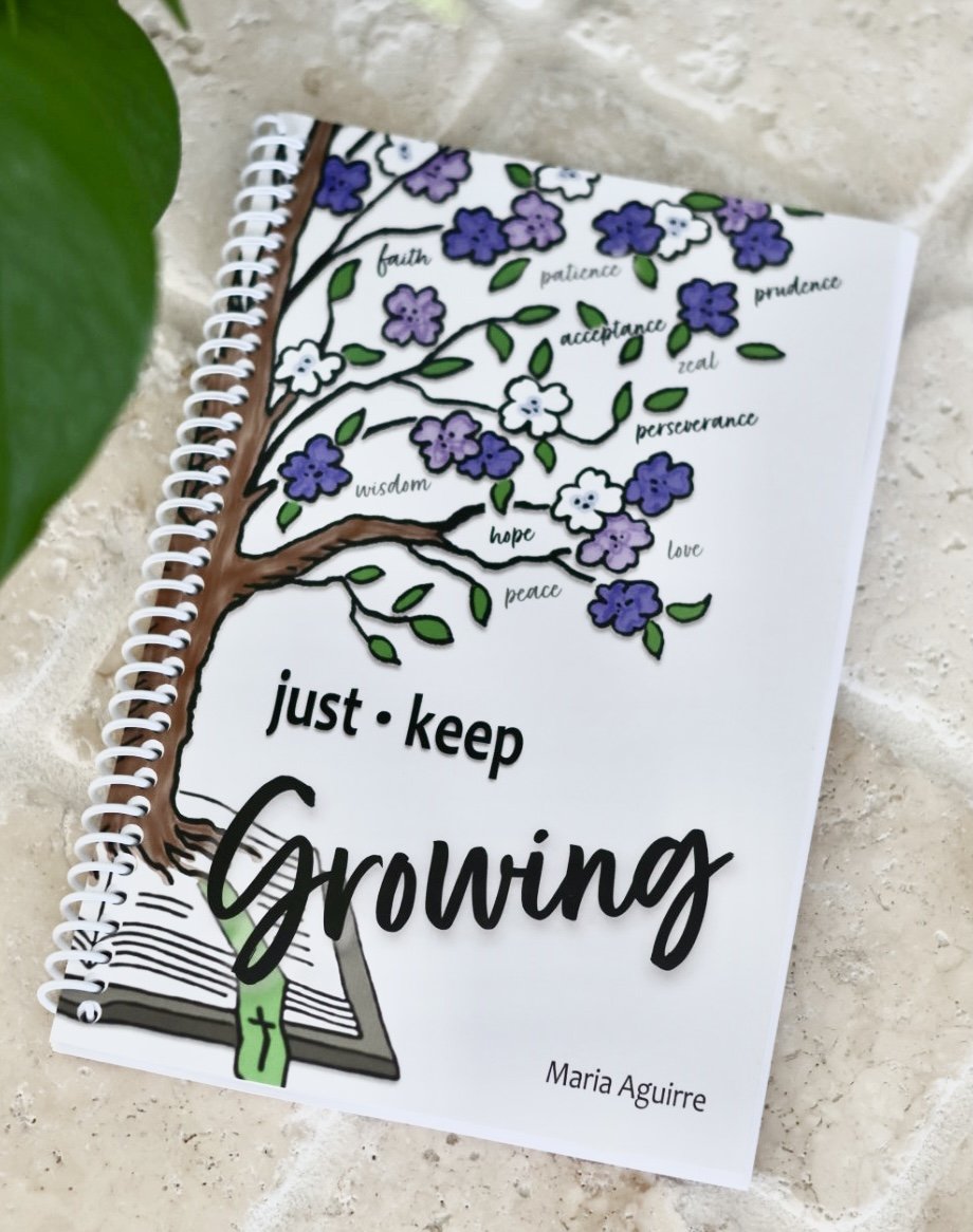 A spiral notebook with a colorful drawing of a tree with purple and white flowers, green leaves, and a brown trunk. The flowers are labeled with words like faith, patience, acceptance, prudence, zeal, wisdom, hope, perseverance, love, and peace. The page features the phrase 'just keep Growing' in large, black cursive and bold fonts, with the author Maria Aguirre's name at the bottom.