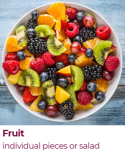 A white bowl filled with mixed fresh berries and sliced fruit, including strawberries, raspberries, blackberries, blueberries, kiwi, orange, and apple, on a blue wooden surface.