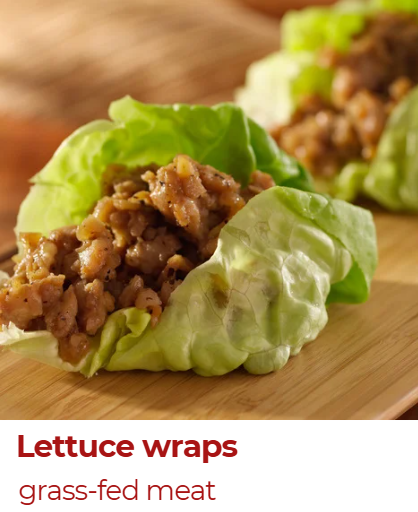 Lettuce wraps with ground meat on a wooden surface.