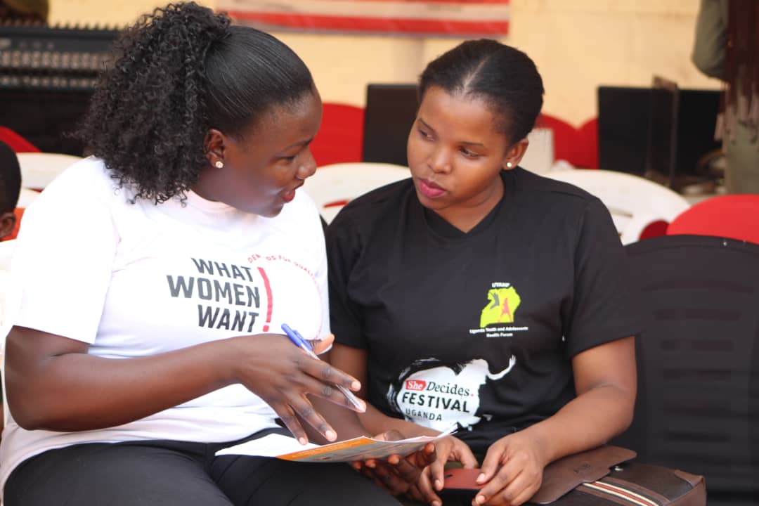 Mobilization_Uganda_WRA Uganda citizen journalist Winfred Ongom engages a woman wbout WWW at the She Decides Festival Kampala.jpg