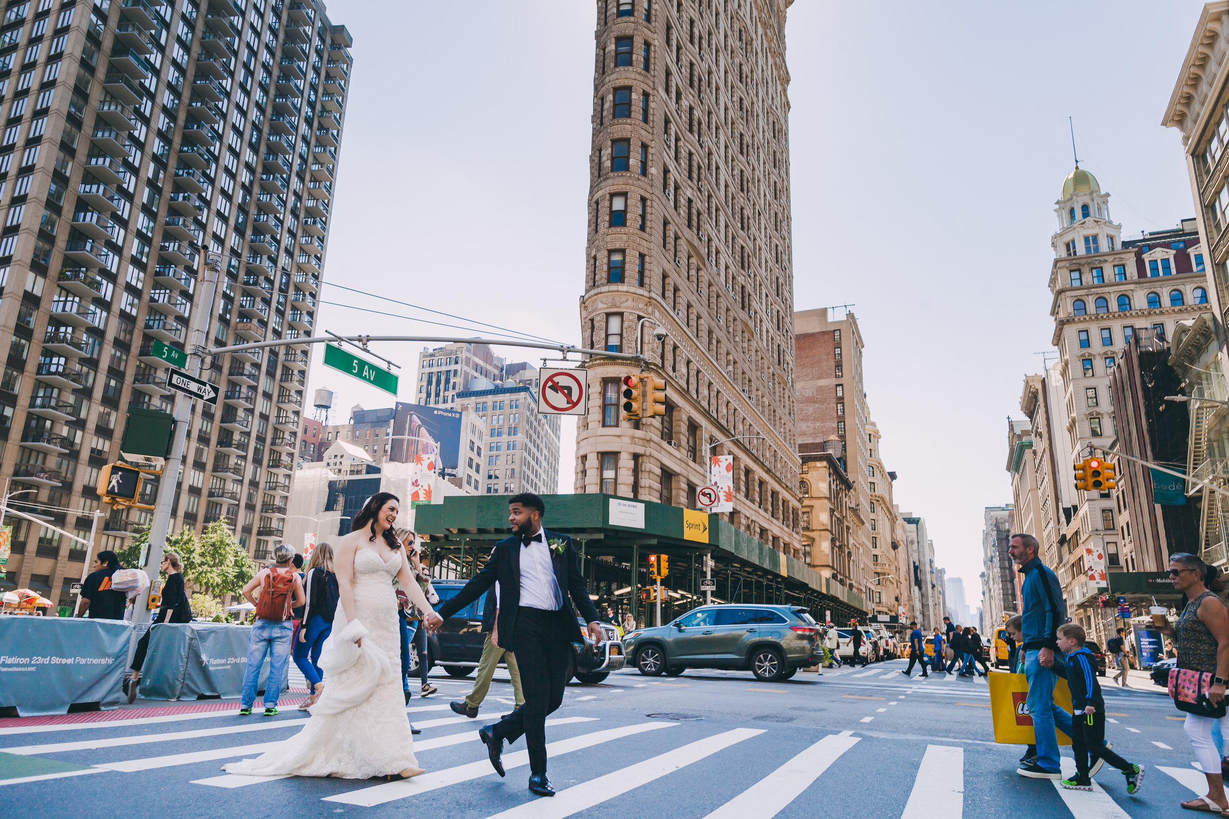 Groom leading his bride across the street in Flatiron after their wedding at the Giraffe Hotel in New York, New York