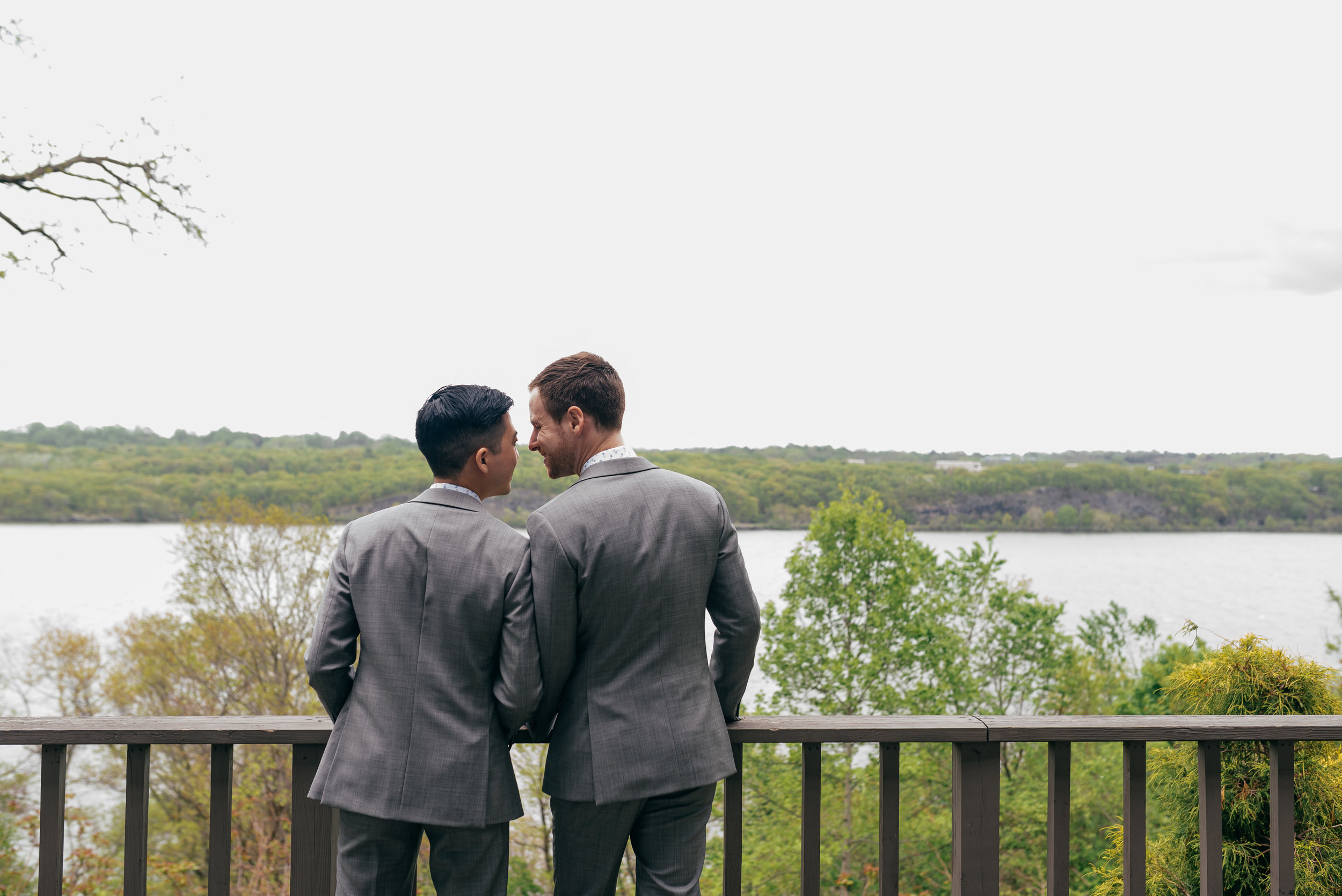 Chad and Eddie helping each other get their suits on and making sure they both look perfect for their wedding ceremony in the Hudson Valley at Buttermilk Falls Inn.