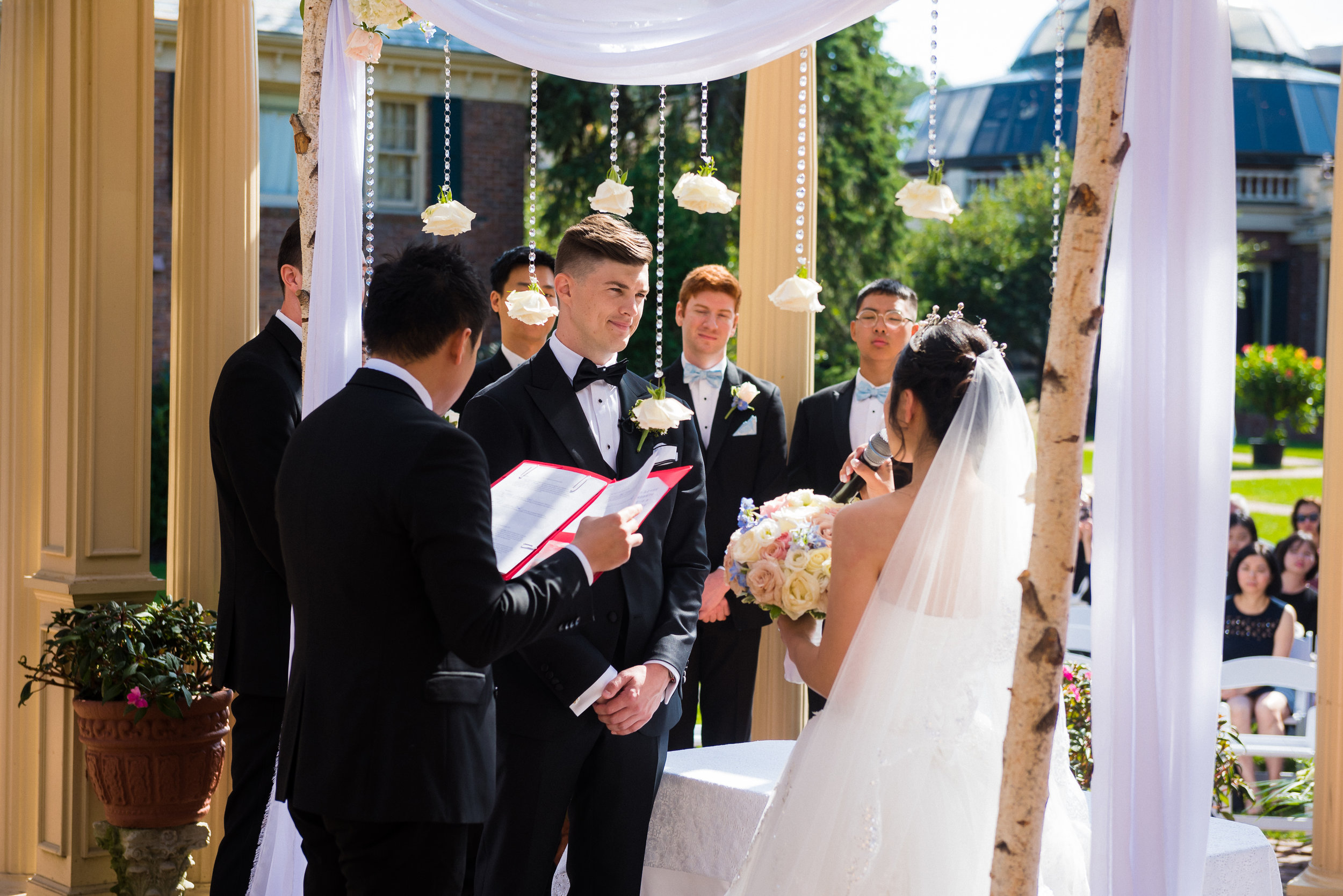 ping and brent both had their own vows during their ceremony. i like the view from behind because you get to see their friends and family in the background watch this new jersey wedding in west orange at the manor.