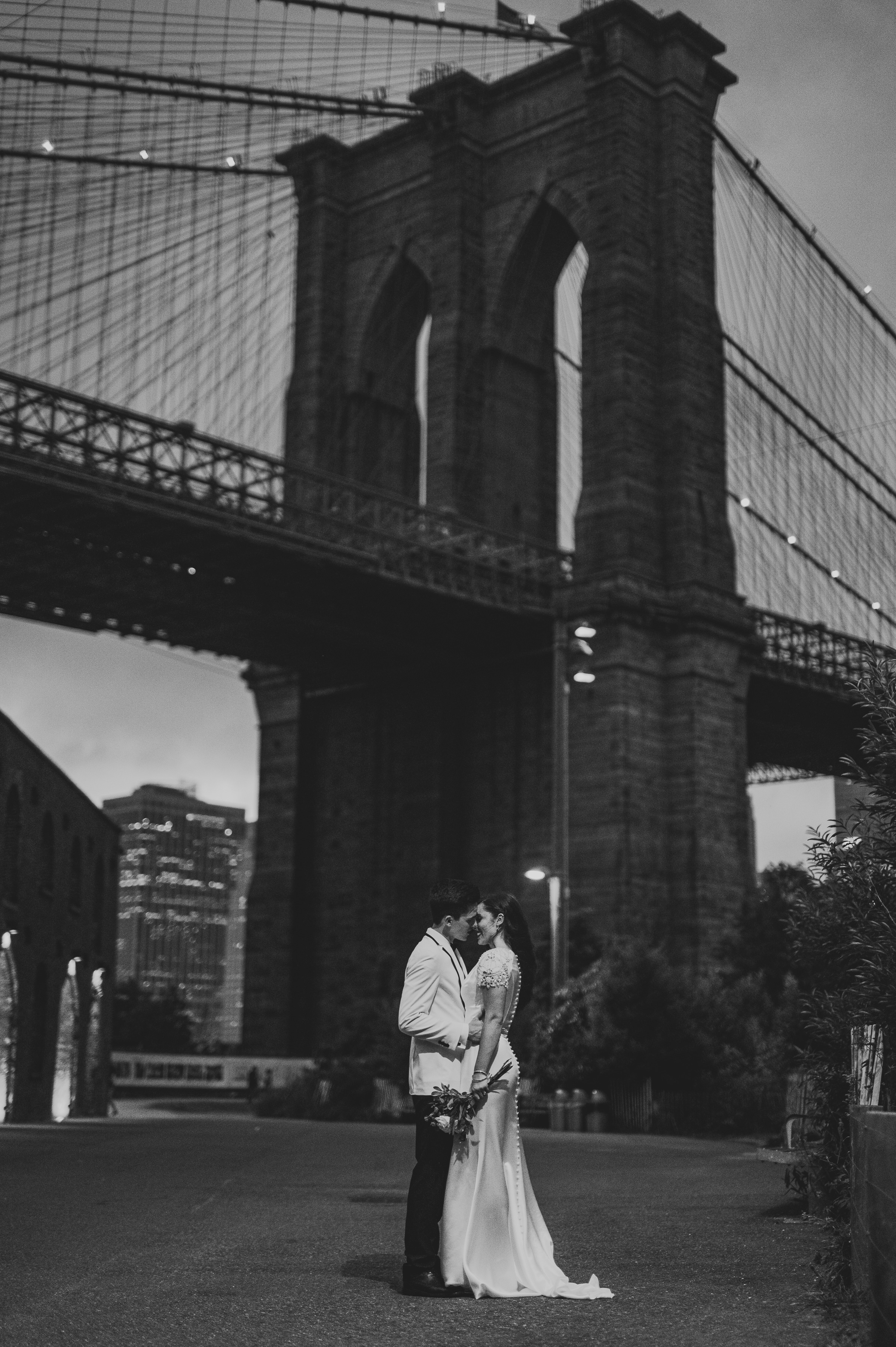 Cinematic portrait of the bride and groom underneath a lamppost in DUMBO