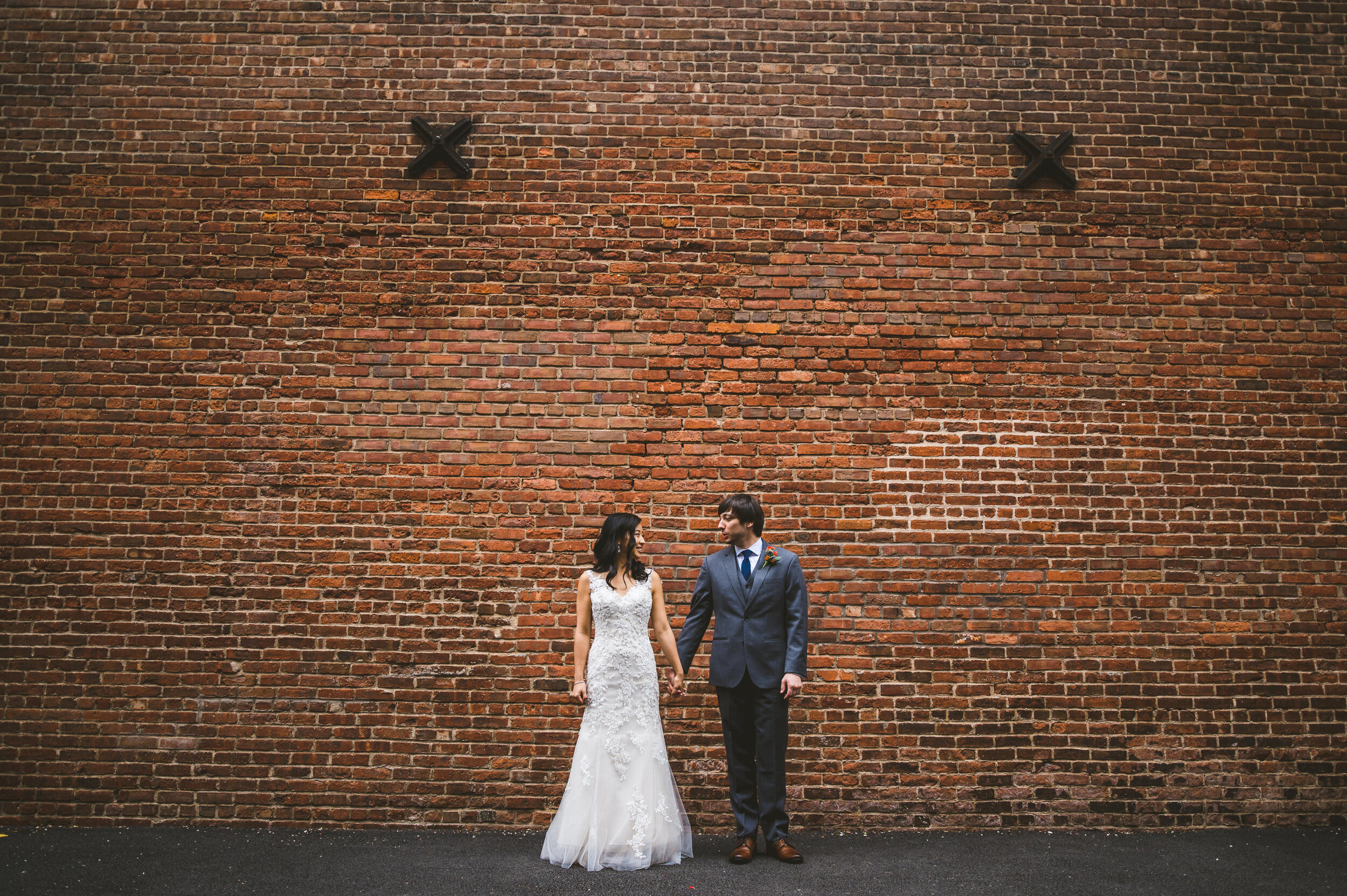 DUMBO wedding portrait with the bride and groom against a wall by the waterfront