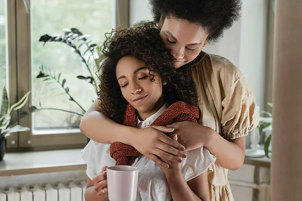 Lesbian couple cuddling, represents how working with a depression therapist in Los Angeles can help you improve your life and relationships.