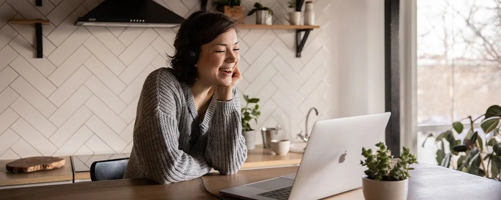 Woman in her kitchen on a video call, represents the convenience and comfort of virtual therapy in Los Angeles and across California.
