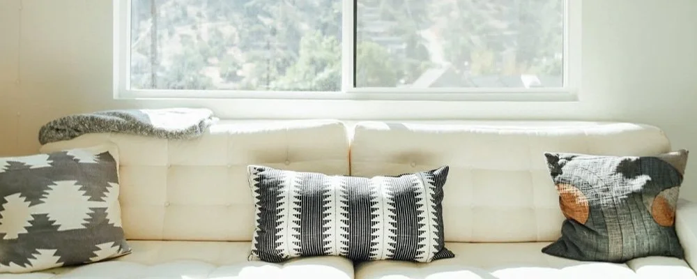 Cozy couch and pillows beside a window, represents a calming space to start EMDR therapy in Los Angeles, CA.