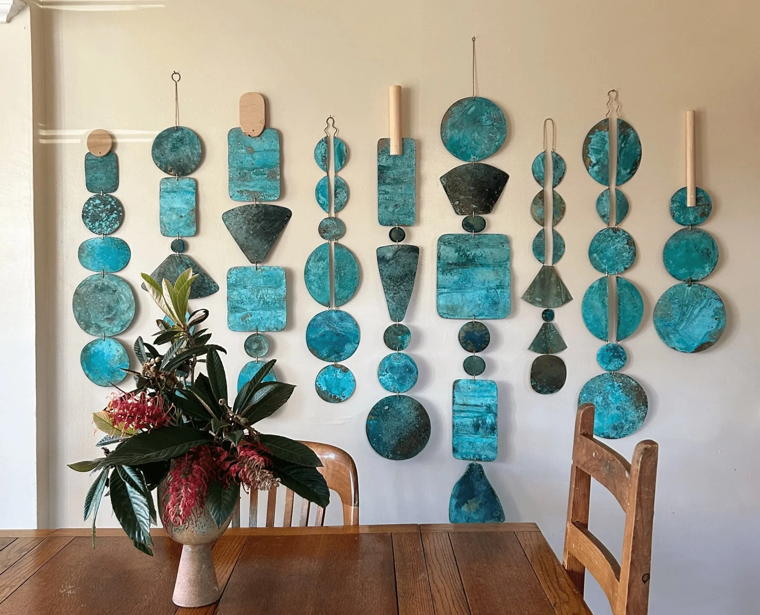 Turquoise-colored verdigris patinated metal wall sculptures.