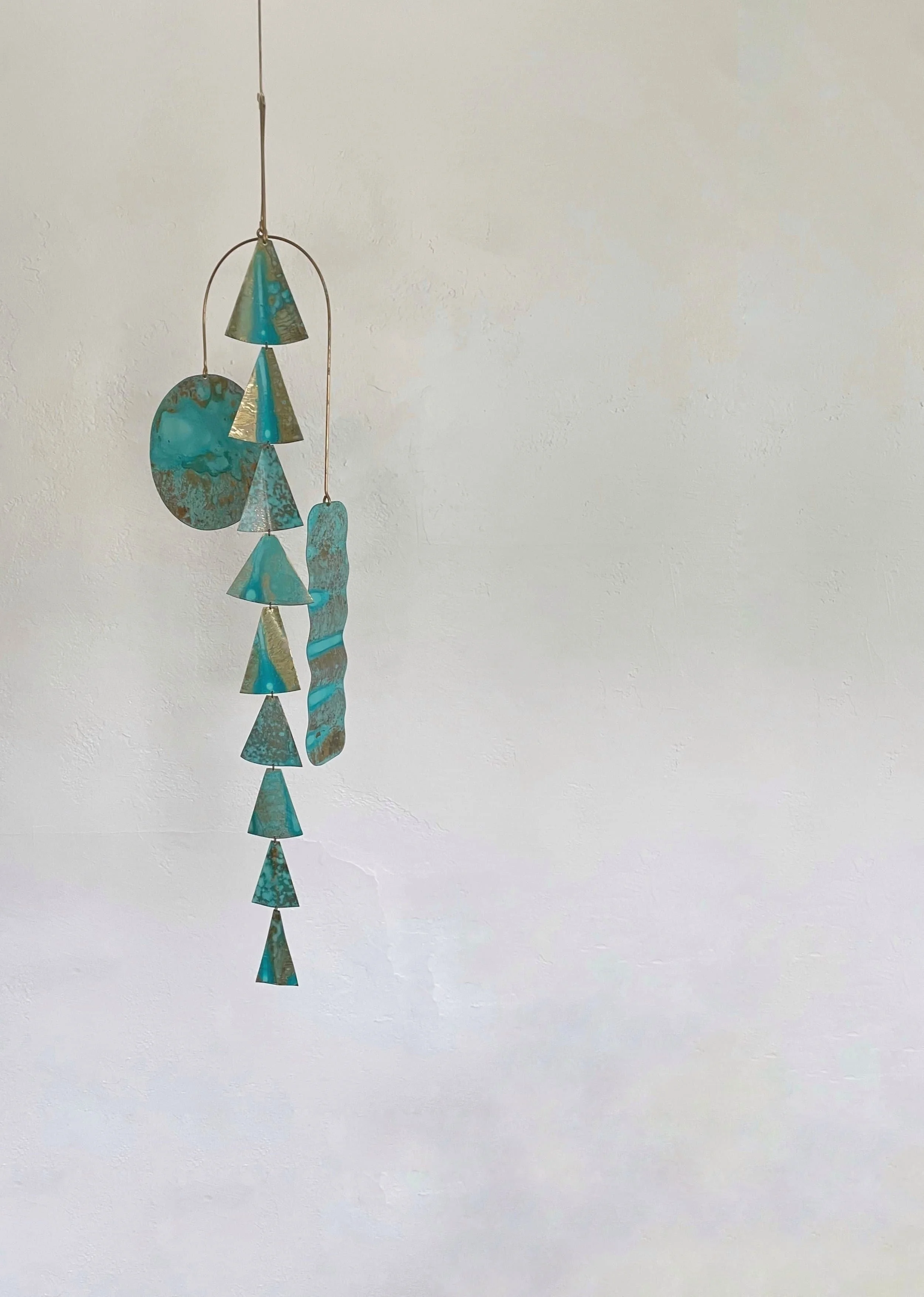 Hanging turquoise-colored verdigris patinated metal wall kinetic sculpture.