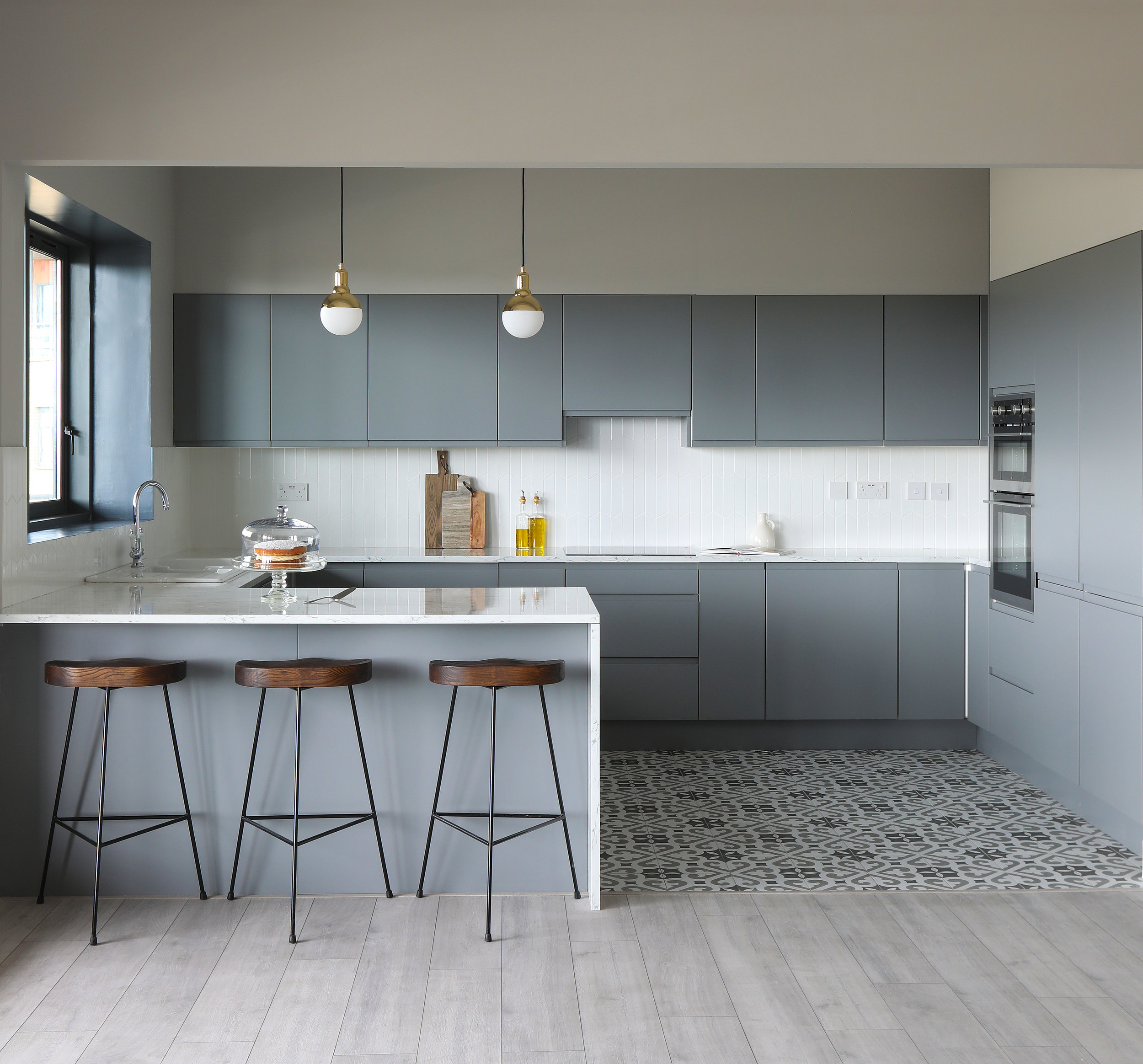 light grey handless kitchen cabinets and black and white floor tiles