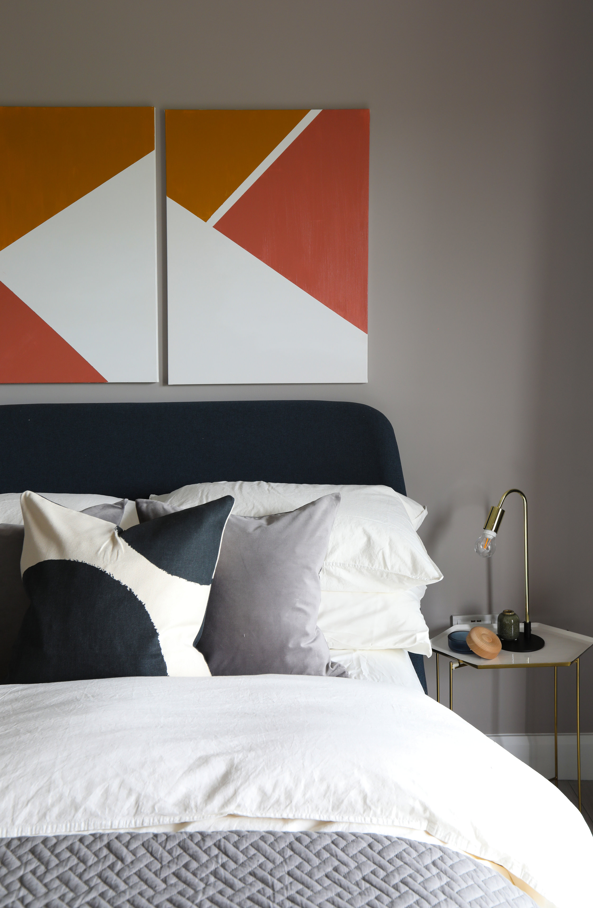 grey bed with orange artwork above