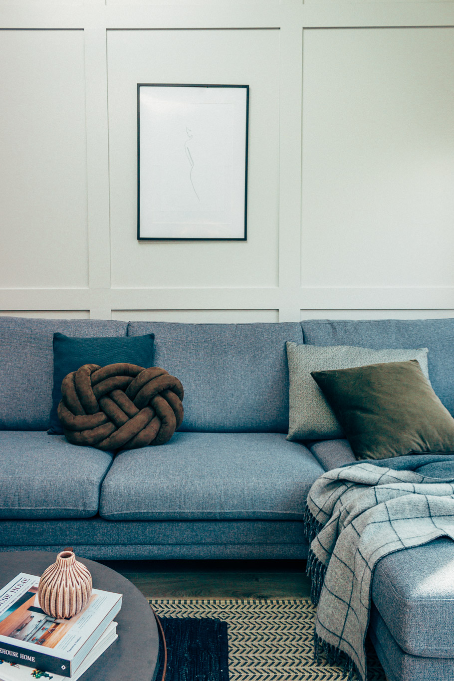 blue couch and white panelled wall
