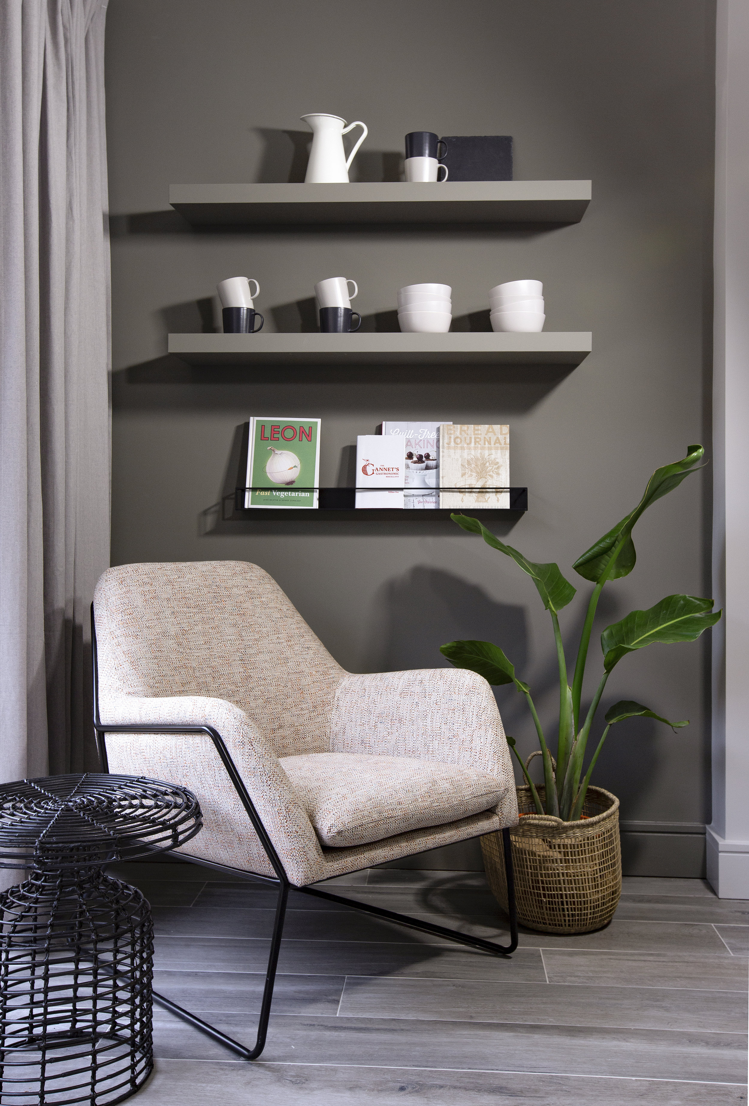 grey floating shelves and cream armchair