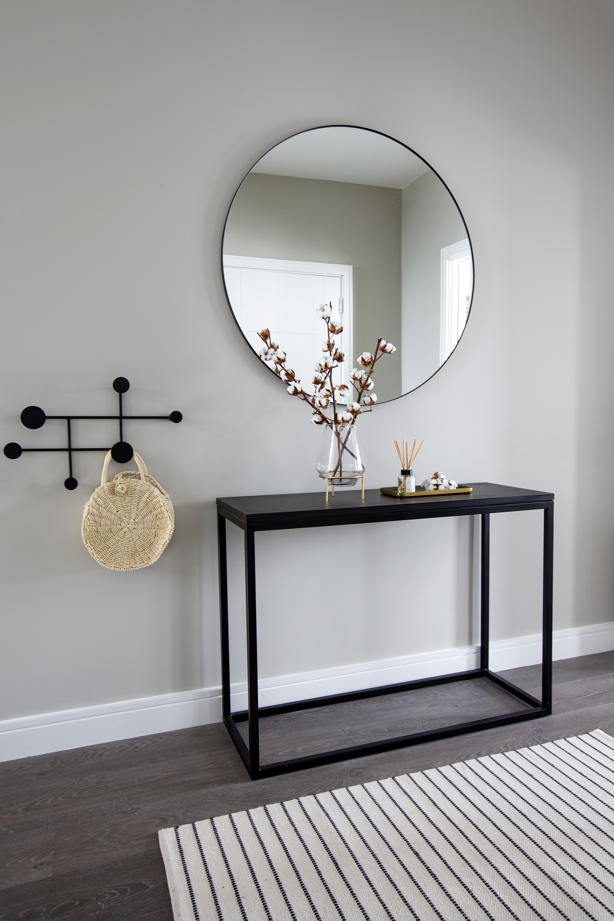 simple black hallway stand and circle mirror