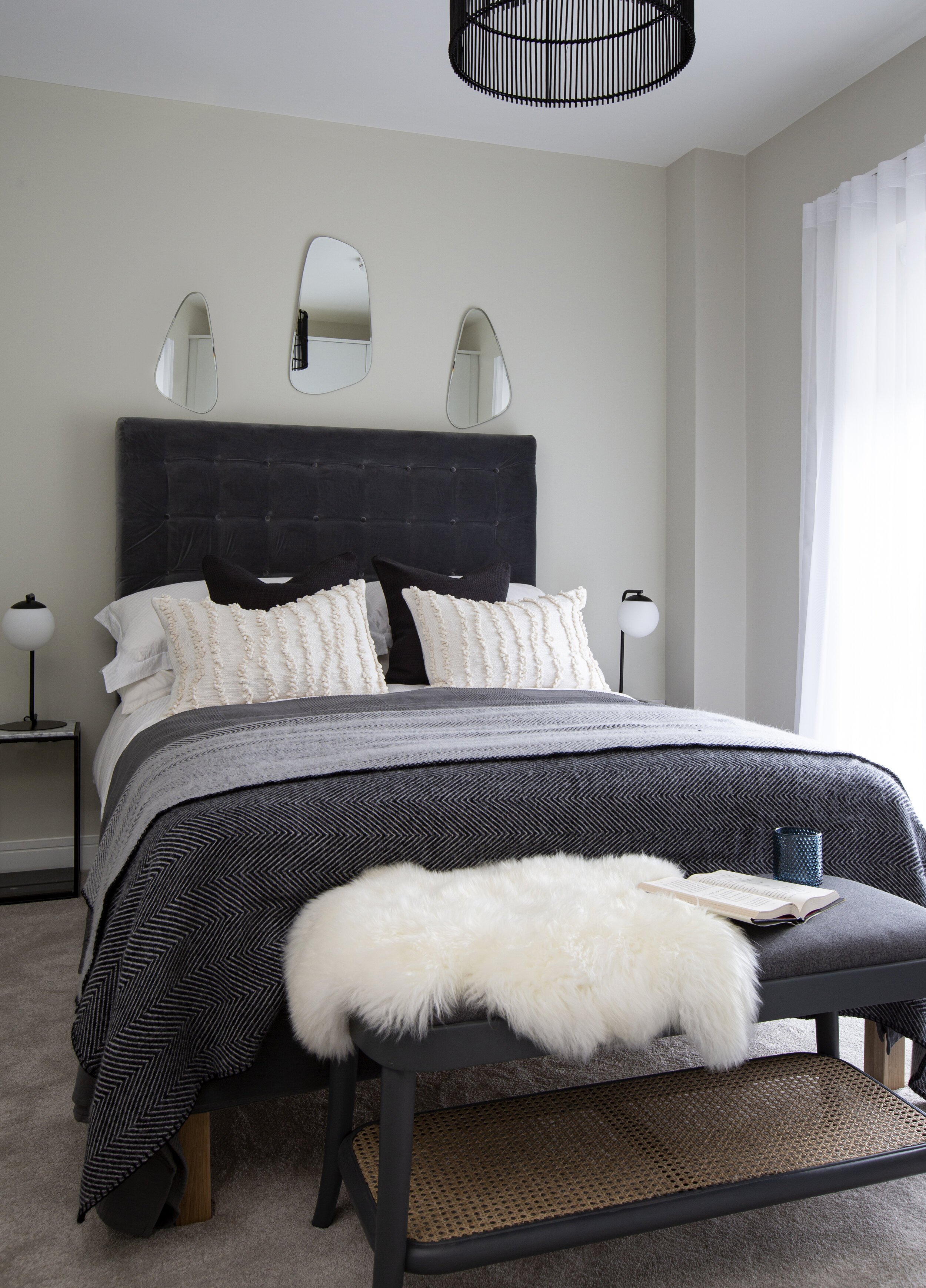 navy and white bed,  small asymmetrical mirrors