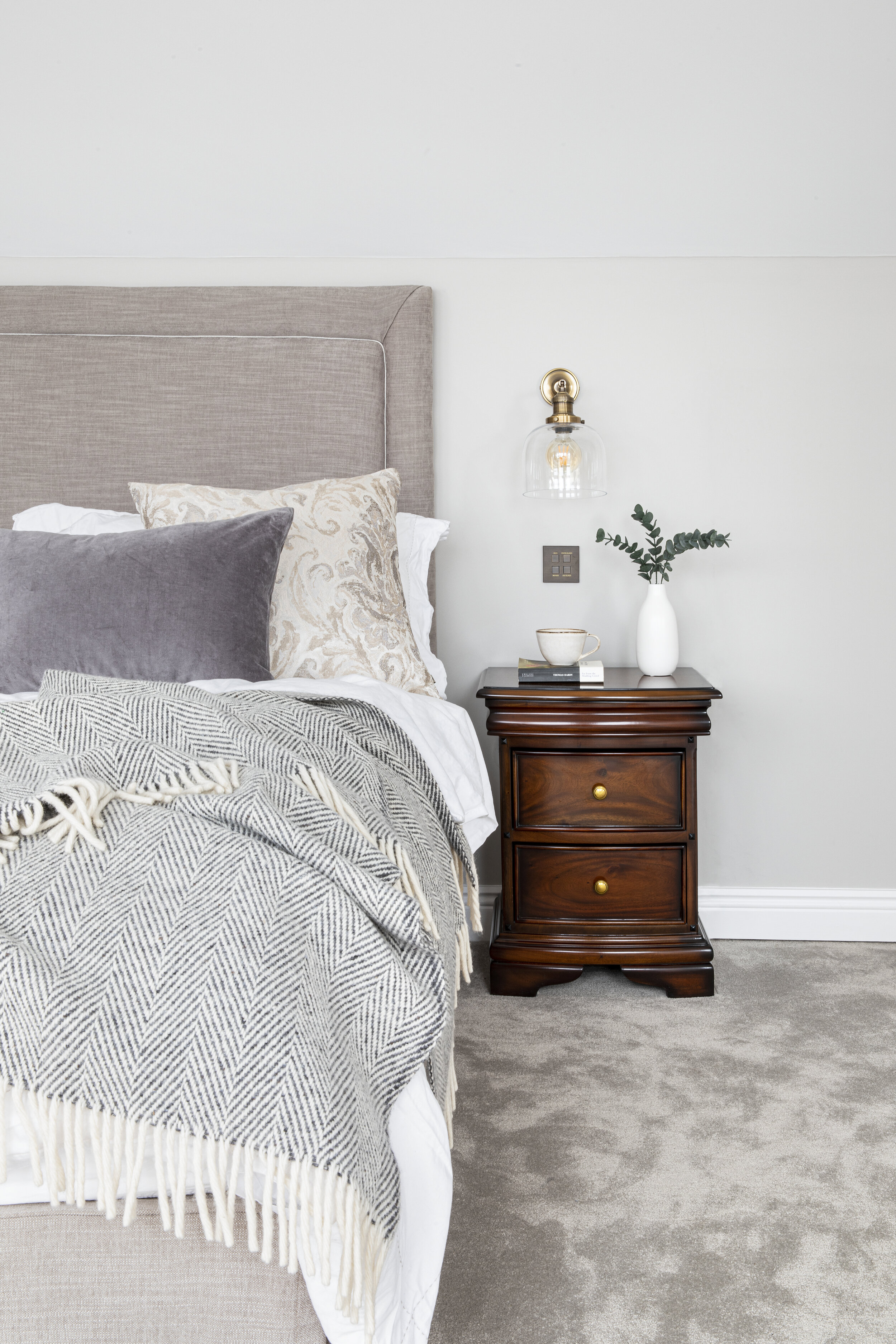 plush grey bedroom carpet and dark wood bedside table