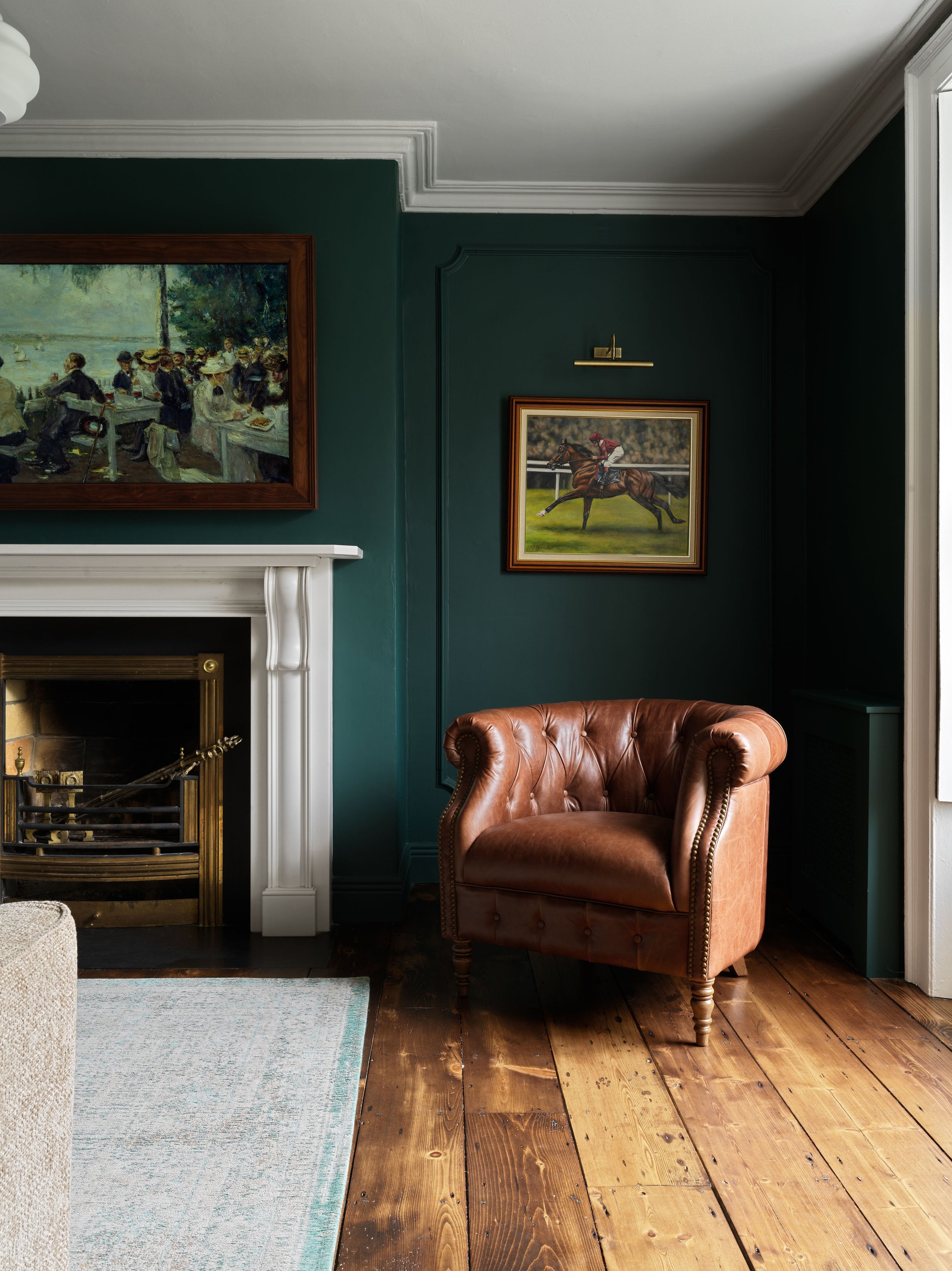 dark green living room with vintage fireplace and leather armchair