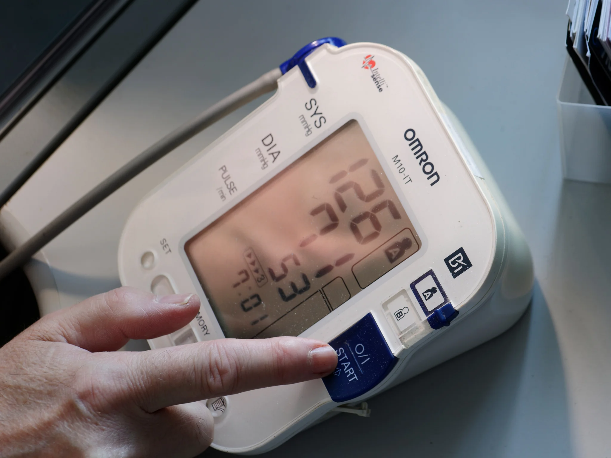 Face in BP monitor with finger over on/off switch. Taken by Graham Land, 6th July, 2018