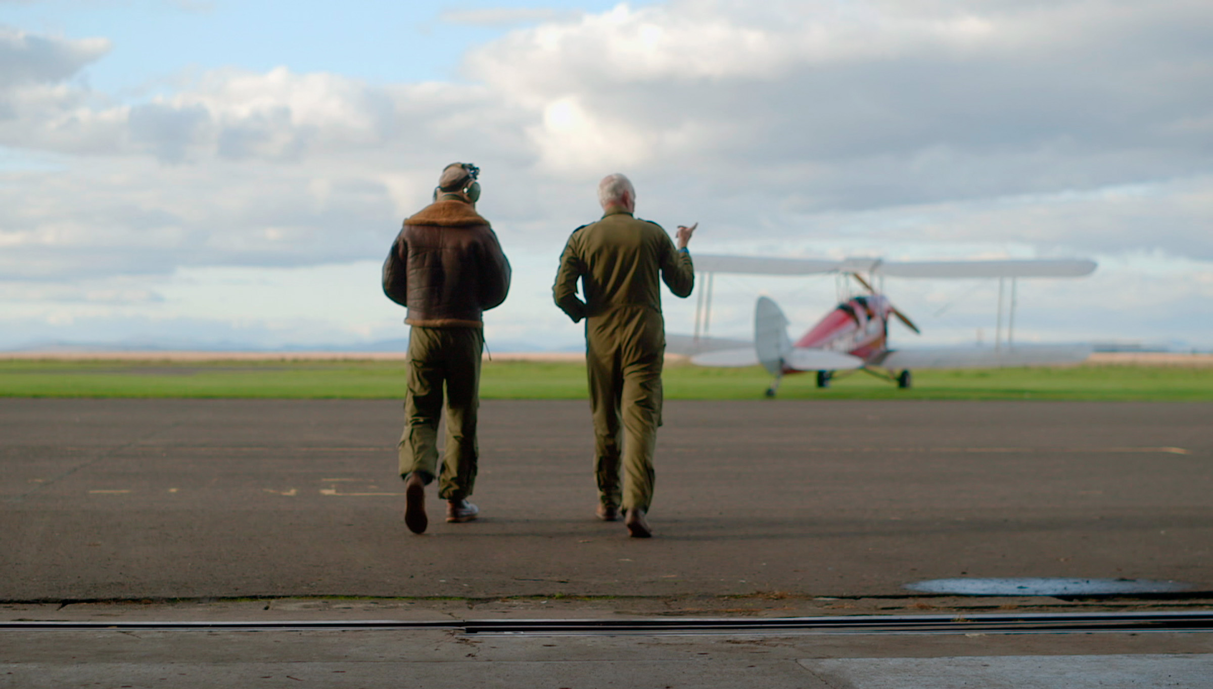 James Crawford and William Mackaness walking over runway to Tiger Moth, Scotland from the Sky