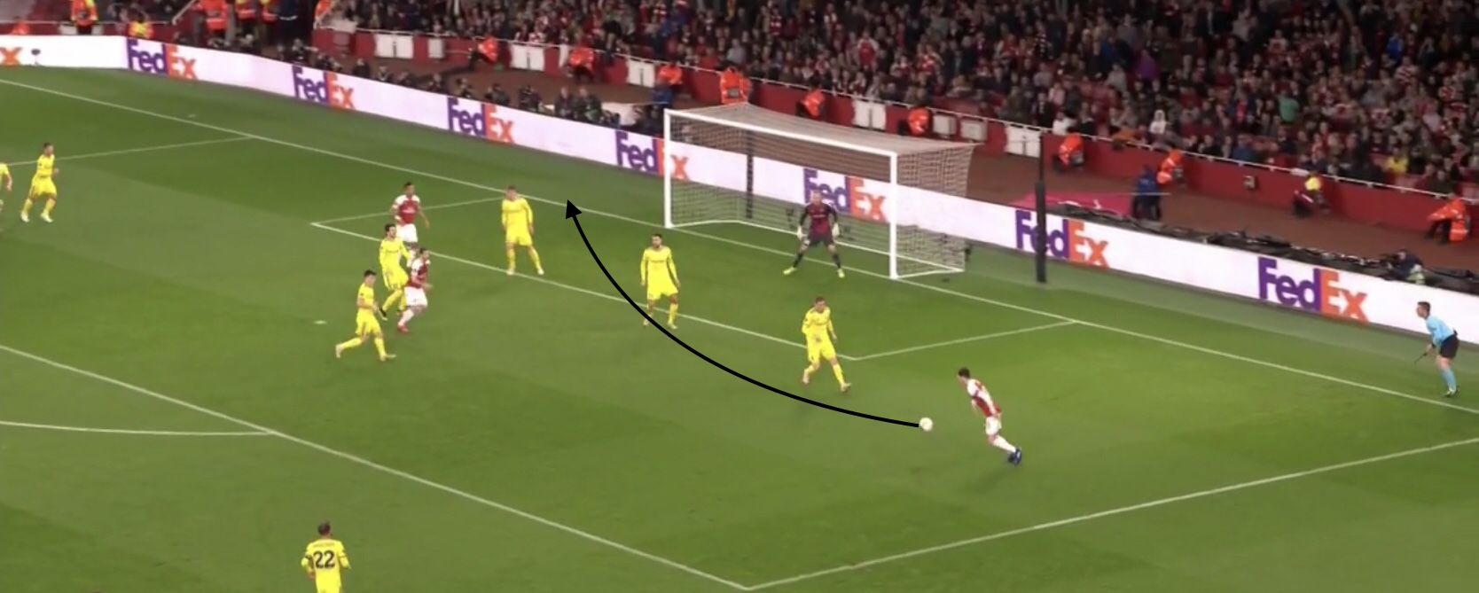 In this photo, Ozil has made a run to the back post and received a cross from the opposite side of the field. He adjust his body to face the goal and chest with his first touch then clips a cross to the back post with his second touch, again playing a forward penetrating pass.