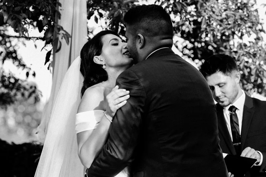 Bride and groom kiss at wedding ceremony.