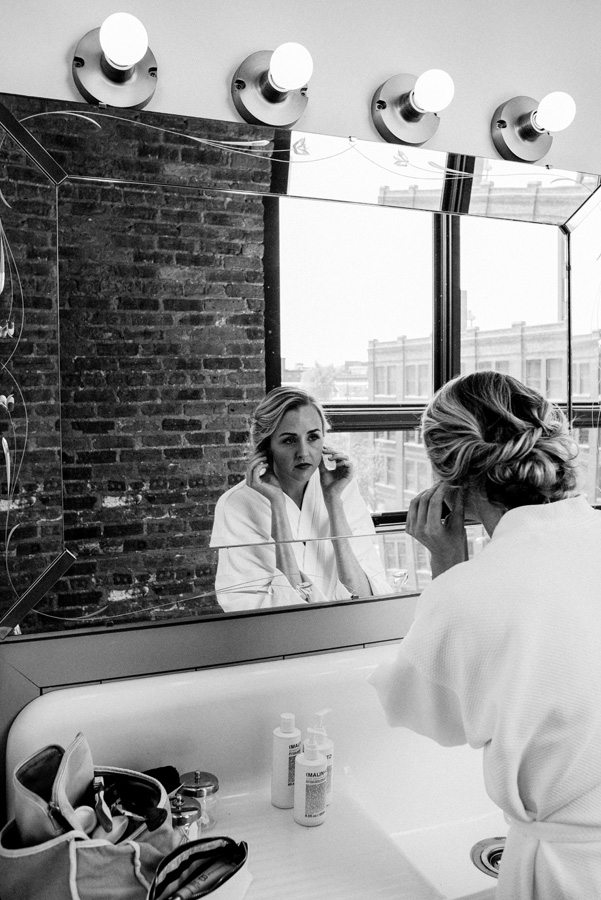 Bride putting her earrings in.