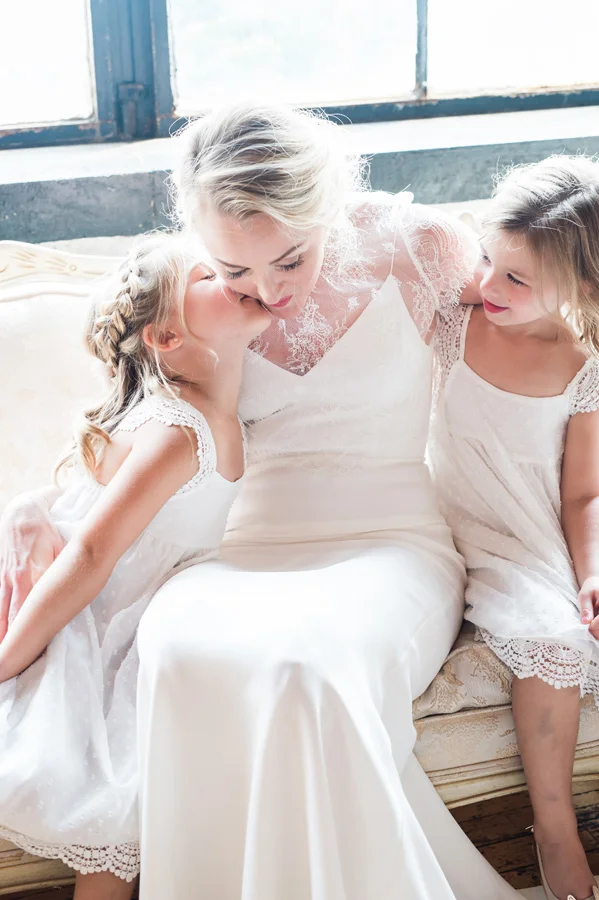 Bride gets a kiss from her flower girls.