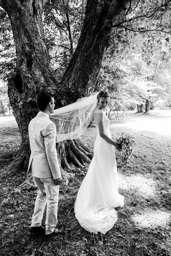 Bride and groom first look under an old tree.