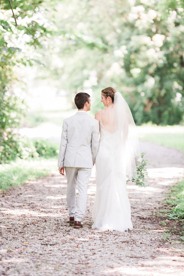 Bride and groom walking along path.
