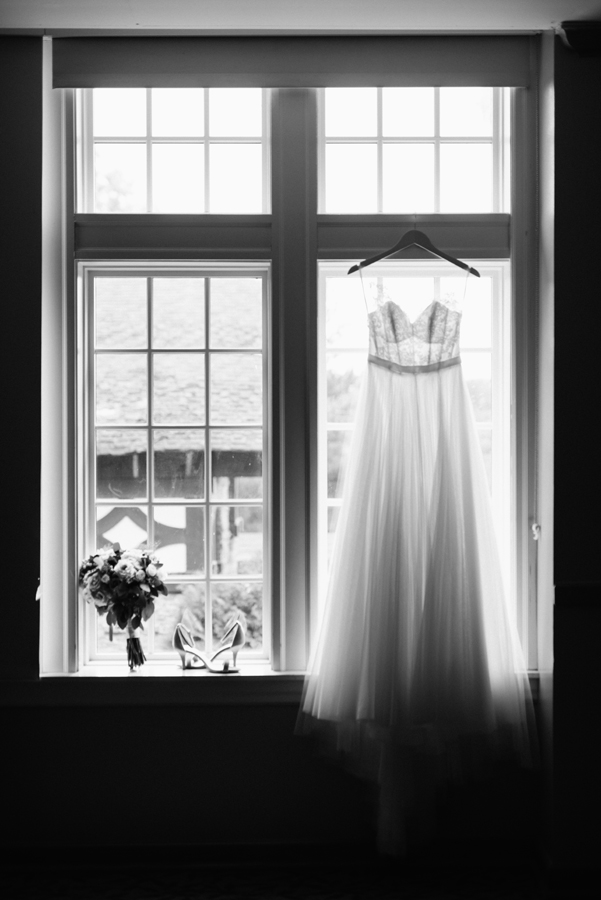 Wedding dress hanging up in window.