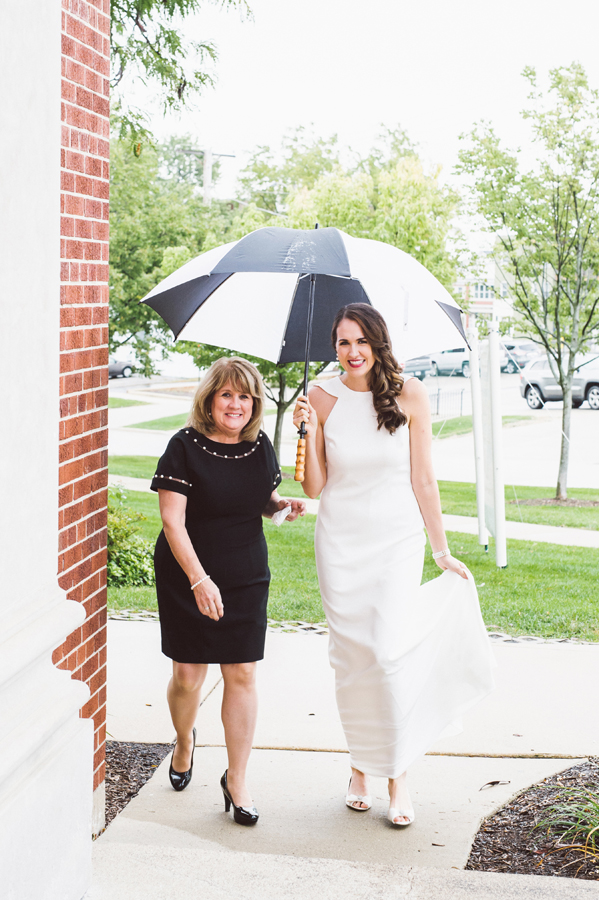 Mom walks bride into church on a rainy day.