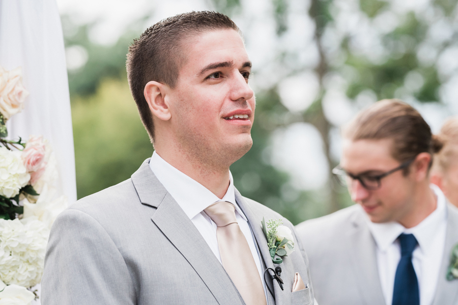 Groom watches his bride walk down the aisle.