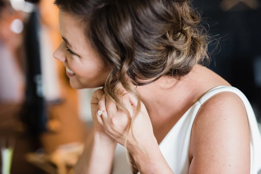 Bride puts her earrings on.