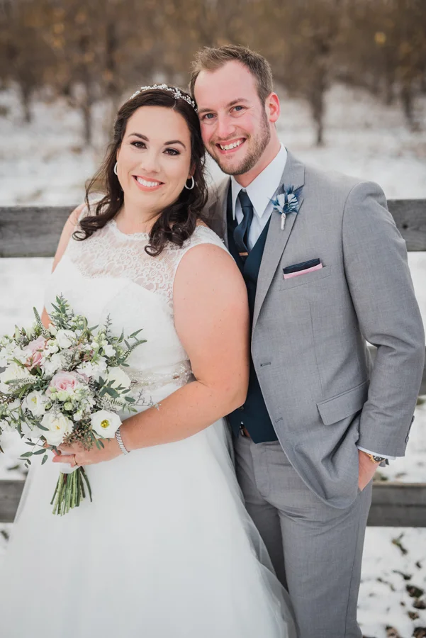 Portrait of bride and groom in orchard.