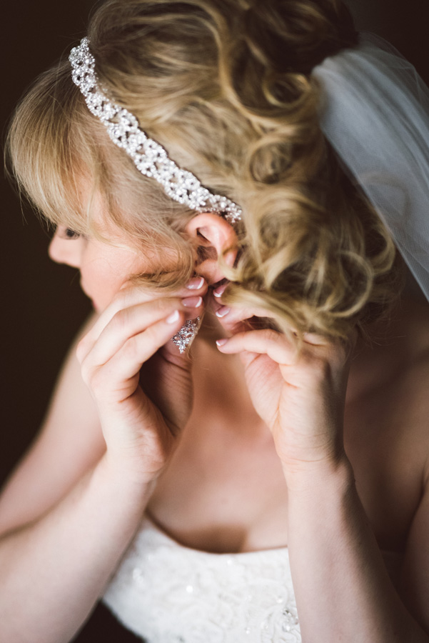 Bride puts her earrings in.