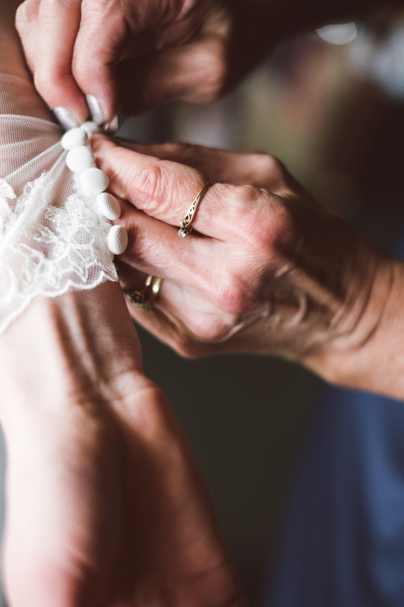 Mom helping bride with her dress.