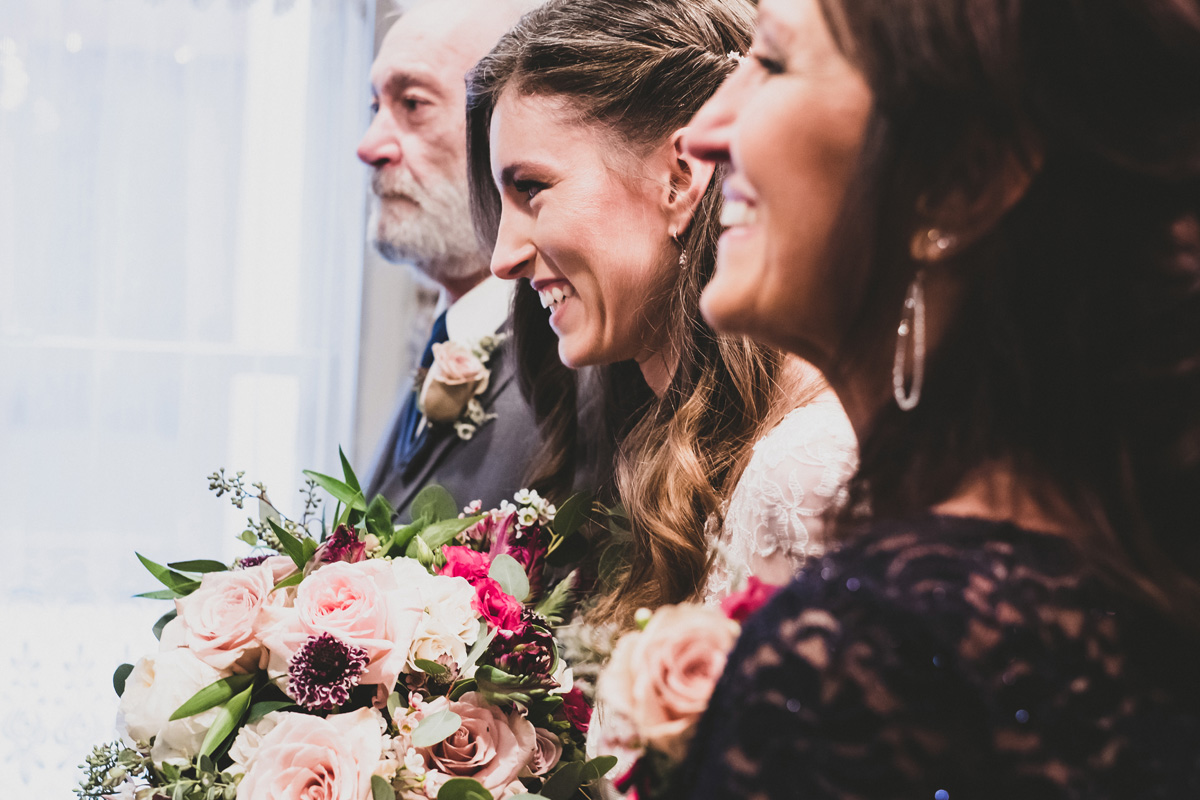 Bride with her parents at ceremony.