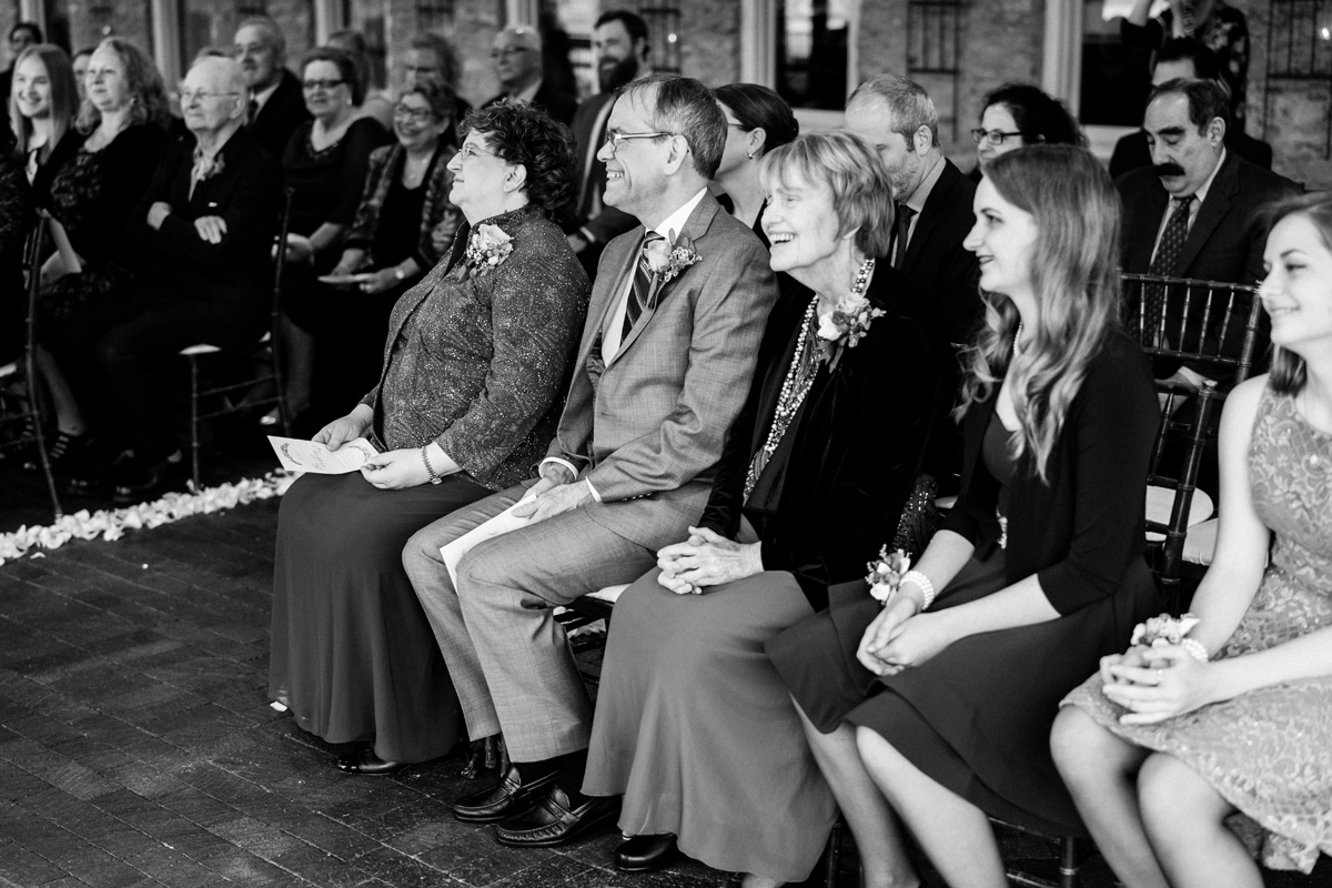 Grooms parents watch wedding ceremony.